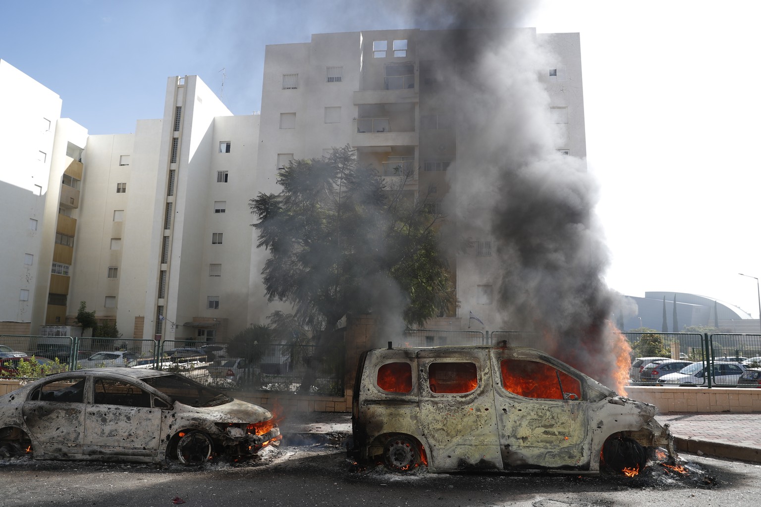 epa10904795 Burning vehicles in the Israeli city of Ashkelon following rocket launches from Gaza, 07 October 2023. Rocket barrages were launched from the Gaza Strip early Saturday in a surprise attack ...