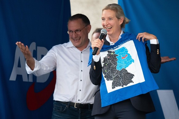 30.08.2024, Sachsen, Görlitz: Alice Weidel (r), AfD-Bundesvorsitzende, hält auf einer Wahlkampfveranstaltung ihrer Partei auf dem Marienplatz ein T-Shirt mit der Aufschrift «Ich habe das Glück, dort r ...