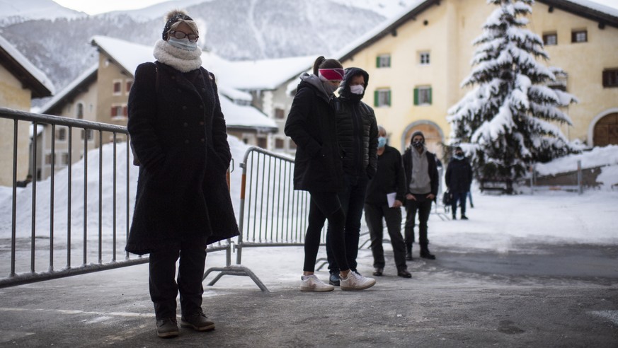 Menschen stehen an bei Covid-19 Flaechentests, aufgenommen am Freitag, 11. Dezember 2020, in Zuoz. Der Kanton Graubuenden fuehrt derzeit in drei Regionen freiwillige Flaechentests als Pilotprojekt dur ...