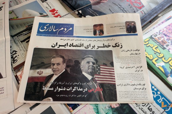 epa12093019 A copy of the Iranian daily newspaper Mardom Salari entitled &#039;Encouragement in the tough Muscat negotiations&#039; carrying a picture of Iranian Foreign Minister Abbas Araghchi and US ...