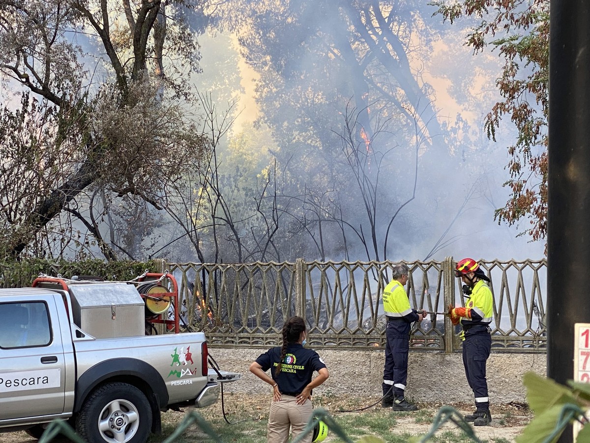 epa09386222 Firefighters battle the flames from fire in the Pineta Dannunziana nature reserve in Pescara, Italy, 01 August 2021. The flames have reached the houses an five people are reported to be ho ...