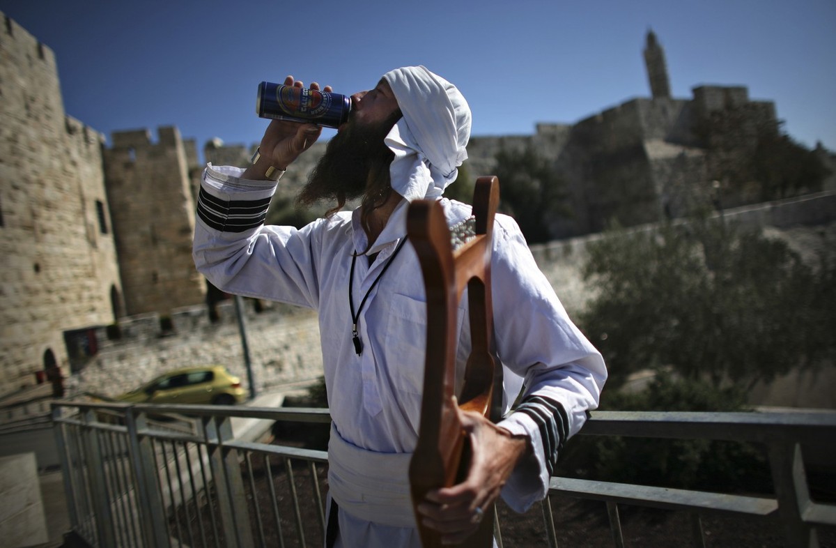 An Israeli musician wears traditional dress as he drinks a beer outside Jerusalem's Old City Friday, Nov. 7, 2008. U.S. Secretary of State Condoleezza Rice said Friday that Israeli-Palestinian ne ...