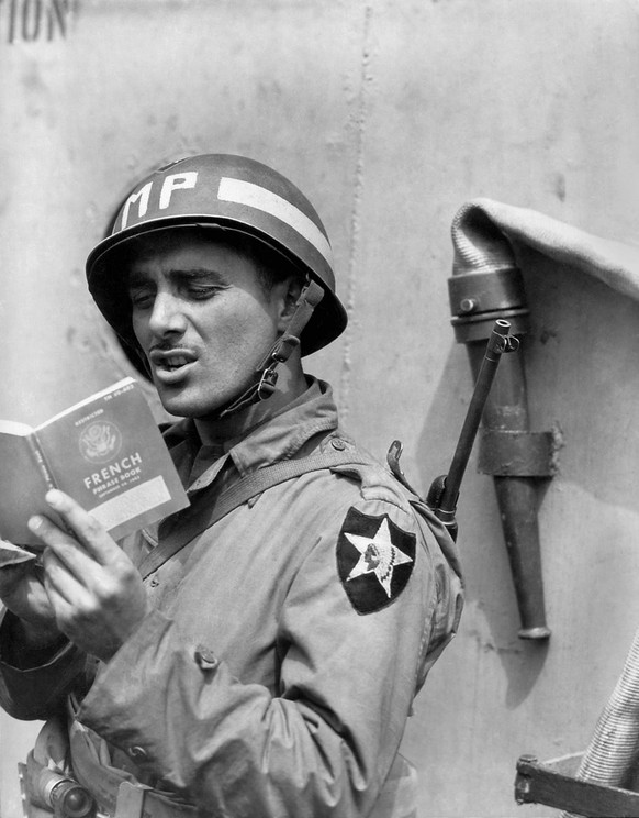 U.S. Army MP Military Police practices French on a ship taking him to Normandy. June 15, 1944. World War 2. BSLOC2014277 Courtesy Everett Collection PUBLICATIONxINxGERxSUIxAUTxONLY Copyright: xCourtes ...