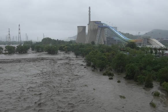 A swollen Yongding river floods the banks near the Shougang park as continuous rain fall triggers alerts in Beijing, Monday, July 31, 2023. (AP Photo/Andy Wong)