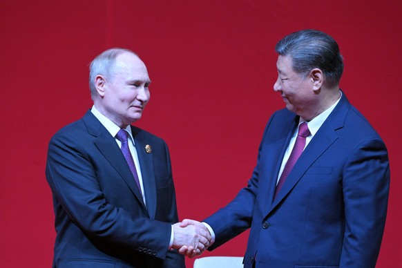 epa11344901 Russian President Vladimir Putin (L) and Chinese President Xi Jinping shake hands during a concert marking the 75th anniversary of the establishment of diplomatic relations between Russia  ...