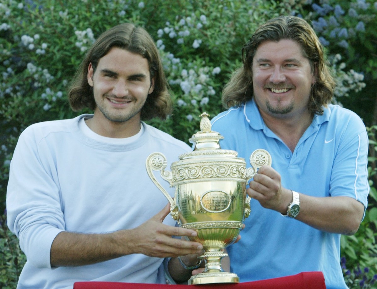 Switzerland's Roger Federer and his coach Peter Lundgren, pose with the Men's Singles trophy after he defeated Australia's Mark Philippoussis in the final of the All England Lawn Tennis ...