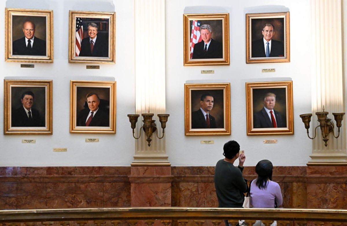 DENVER, CO - MARCH 24: Edward Xu, left, and Feiya Ju, look at the portrait of President Donald Trump, right, that hangs on walls in the rotunda on the third floor of the Colorado State Capitol in Denv ...