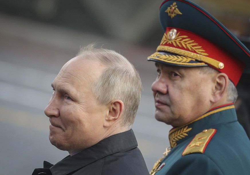 epa09935474 Russian President Vladimir Putin (L) speaks with Russian Defense Minister Sergei Shoigu as they attend the Victory Day military parade on the Red Square in Moscow, Russia, 09 May 2022. Rus ...