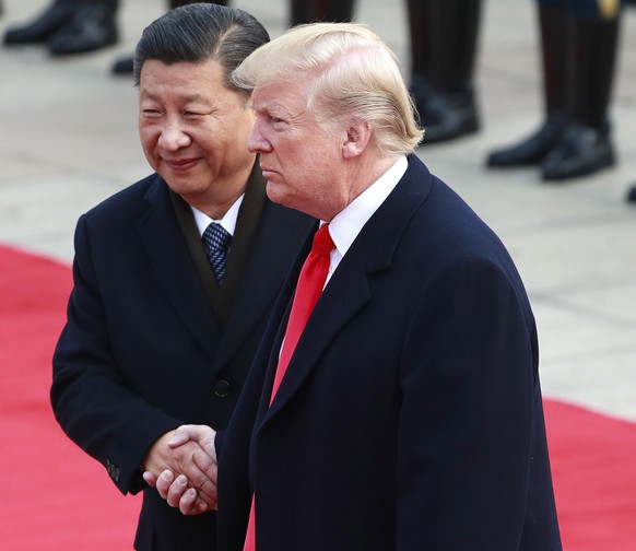 epa07260751 (FILE) - US President Donald J. Trump (R) shake hands with his Chinese counterpart Xi Jinping (L) after reviewing honor guards during a welcome ceremony in Beijing, China, 09 November 2017 ...
