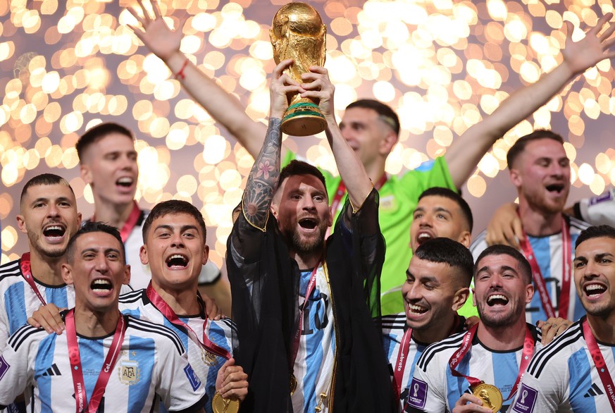 epaselect epa10373019 Lionel Messi (C) of Argentina lifts the World Cup trophy after winning the FIFA World Cup 2022 Final between Argentina and France at Lusail stadium, Lusail, Qatar, 18 December 20 ...