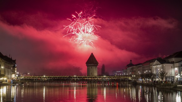 The New year fireworks explode over the famous Chapel Bridge and Old Town in Lucerne, Switzerland, on Wednesday, January 1, 2025. (KEYSTONE/Urs Flueeler)..Mit einem Feuerwerk ueber dem Luzerner Seebec ...
