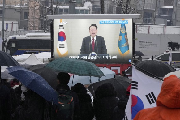 A TV screen shows a file image of South Korean President Yoon Suk Yeol as supporters of impeached Yoon attend a rally to oppose his impeachment near the presidential residence in Seoul, South Korea, S ...