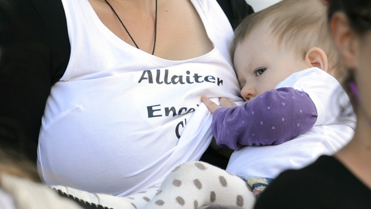 A mom nurses a baby during a flash mob protest to promote breastfeeding during the at the Place de la Riponne, in Lausanne, Saturday, September 13, 2014. 50 women gathered together and feed their baby ...