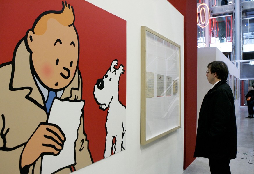 A visitor looks at original letters and an enlarged cartoon of Tintin by Belgian cartoonist Herge at Paris&#039; Pompidou Cultural Center Tuesday, Dec. 19, 2006 in Paris. The Pompidou Center is hostin ...