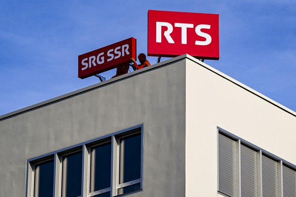 Des ouvriers installent le logo de la RTS (SRG-SSR) sur le nouveau batiment le mardi 4 novembre 2025 sur le site de l&#039;EPFL a Lausanne-Ecublens. La RTS a diffuse mardi matin ses premieres emission ...