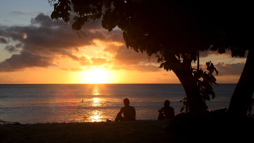 Surfers watch the sun set after surfing along the coast of Kiritimati Island, part of the Pacific Island nation of Kiribati, April 5, 2016. To match Feature PACIFIC-JUSTICE/ REUTERS/Lincoln Feast