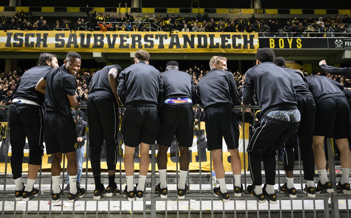 Die Spieler des BSC Young Boys, mit Meschack Elia, 2. von links, der sich umdreht, stehen auf der Barriere und feiern mit den Fans, am Dienstag, 21. Mai 2024 nach der Rueckfahrt von Genf im Stadion Wa ...