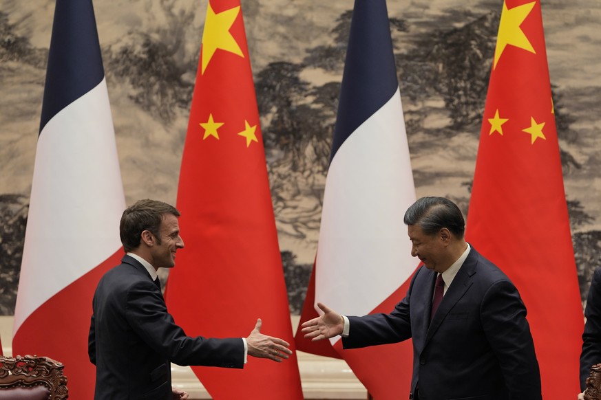 FILE- French President Emmanuel Macron, left, shakes hands with Chinese President Xi Jinping after meeting the press at the Great Hall of the People in Beijing, Thursday, April 6, 2023. Xi will start  ...
