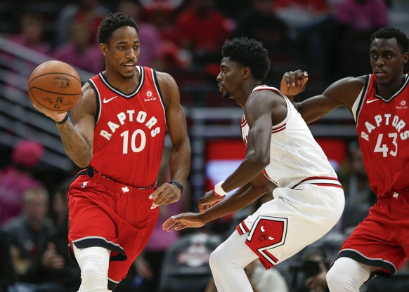 Toronto Raptors guard DeMar DeRozan (10) is defended by Chicago Bulls guard Justin Holiday (7) during the first half of a preseason NBA Basketball Herren USA basketball game at the United Center in Ch ...