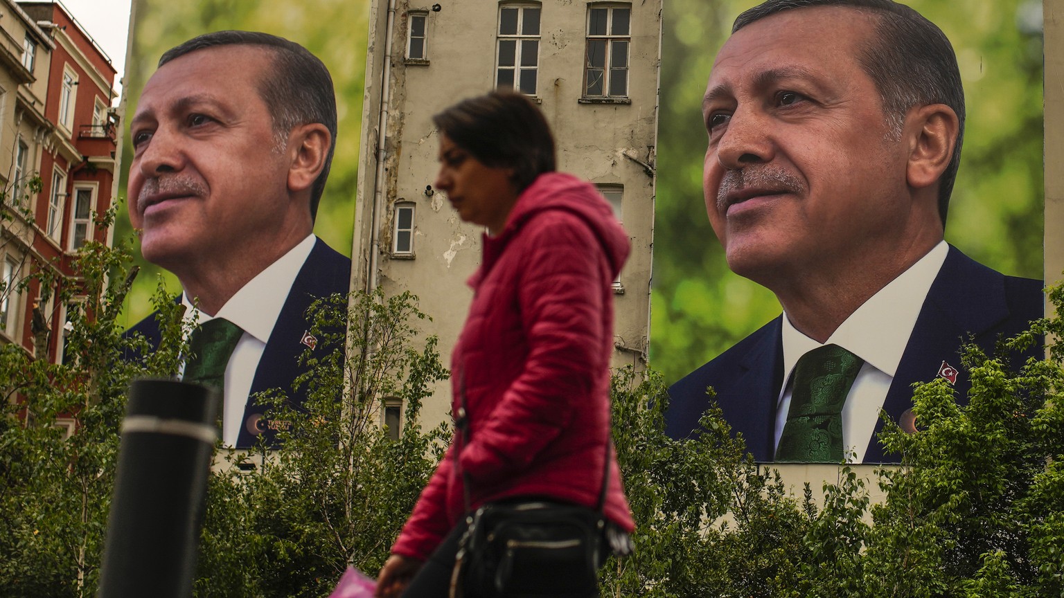 A person walks past billboards of Turkish President and People&#039;s Alliance&#039;s presidential candidate Recep Tayyip Erdogan a day after the presidential election day, in Istanbul, Turkey, Monday ...