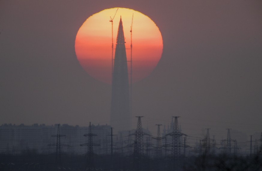 FILE - The Lakhta Centre tower under construction, the headquarters of Russian gas monopoly Gazprom, is silhouetted against the sunset in St. Petersburg, Russia, on April 15, 2018. Russia has been ful ...