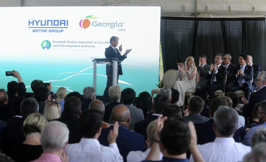 Georgia Governor Bran Kemp celebrates as he officially announces plans By Hyundai Motor Group to build a manufacturing plant at Bryan County mega-site Friday, May 20, 2022 in Ellabell, Ga. The propert ...