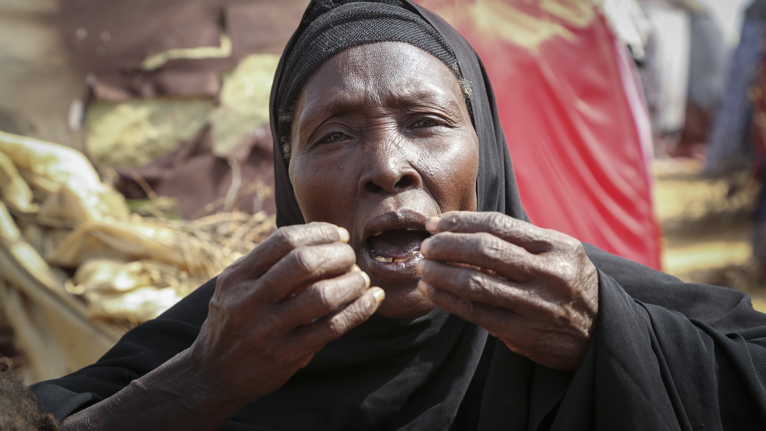 Dhahabo Isse, 60, describes how she fled from the drought without food or water causing four of her children to die of hunger, outside her makeshift tent at a camp for the displaced on the outskirts o ...