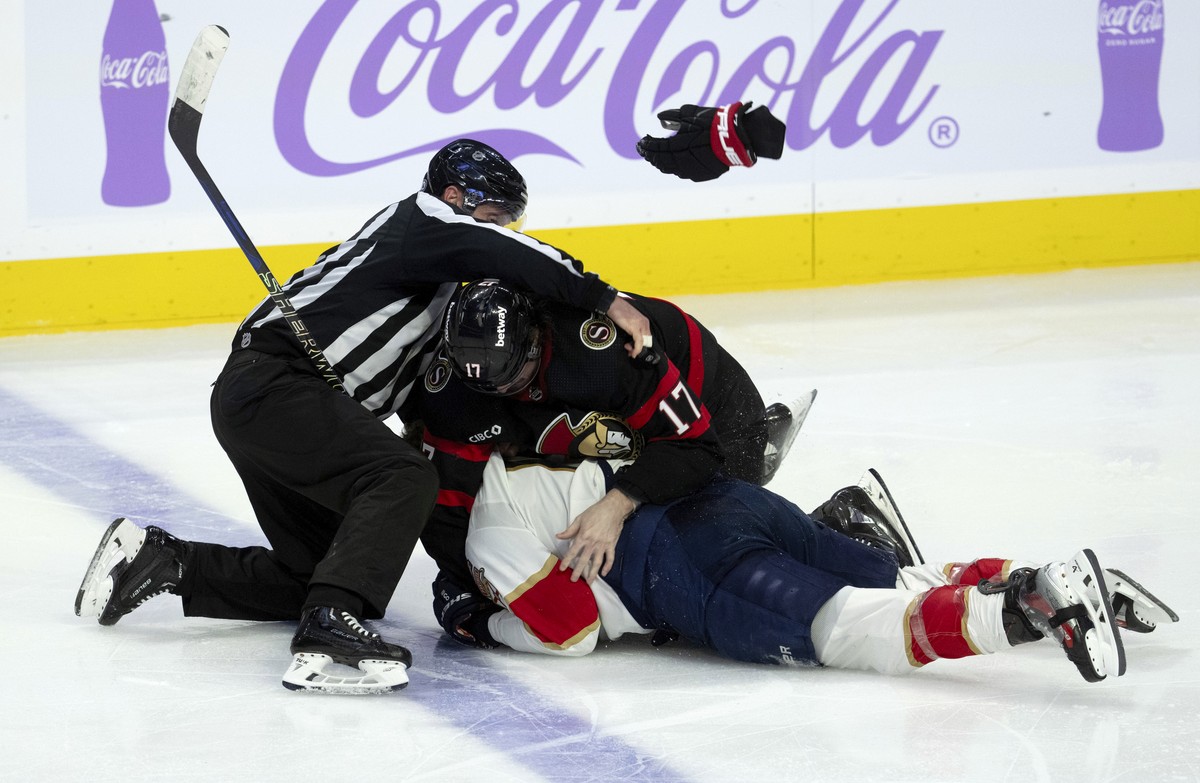The linesman tries to pull Ottawa Senators center Zack MacEwen (17) and Florida Panthers left wing Matthew Tkachuk, bottom, apart during third-period NHL hockey game action in Ottawa, Ontario, Monday, ...