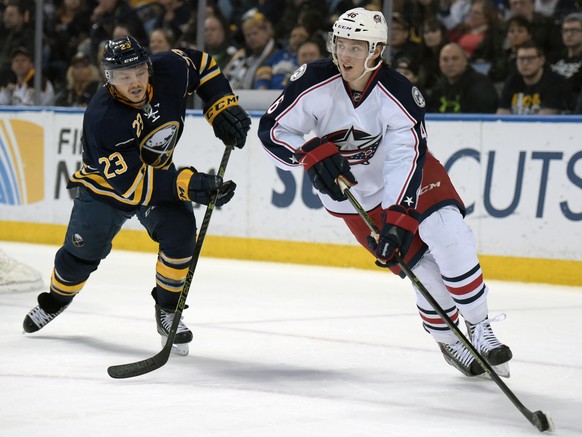 Buffalo Sabres center Sam Reinhart (23) pursues as Columbus Blue Jackets defenseman Dean Kukan (46), of the Czech Republic, looks to pass the puck up ice during the first period of an NHL hockey game, ...