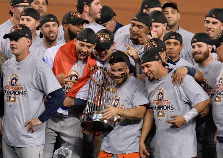 Houston Astros Jose Altuve holds Commissioners Trophy surrounded by teammates after defeating the Los Angeles Dodgers in the 2017 MLB Baseball Herren USA World Series game seven at Dodger Stadium in L ...