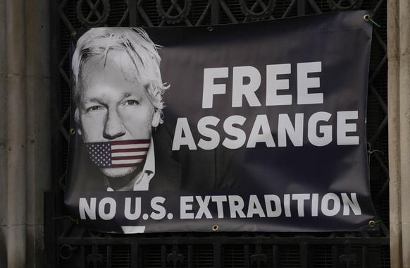 A view of a banner Julian Assange supporters fixed to a railing, outside the High Court in London, Friday, Dec. 10, 2021. Britain