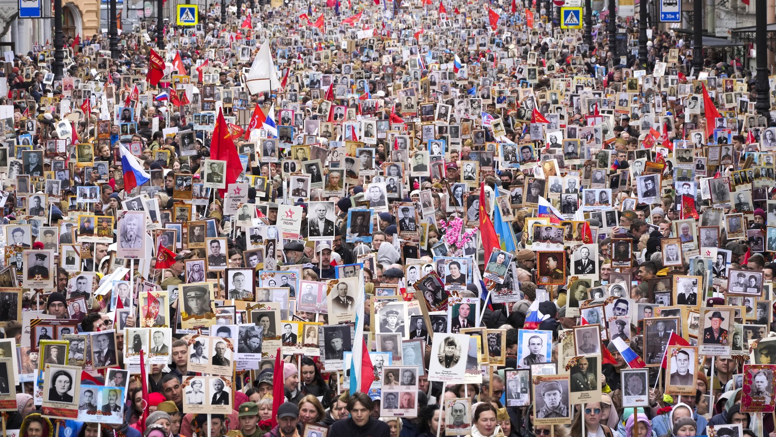 People carry portraits of relatives who fought in World War II, during the Immortal Regiment march in St. Petersburg, Russia, Monday, May 9, 2022, marking the 77th anniversary of the end of World War  ...
