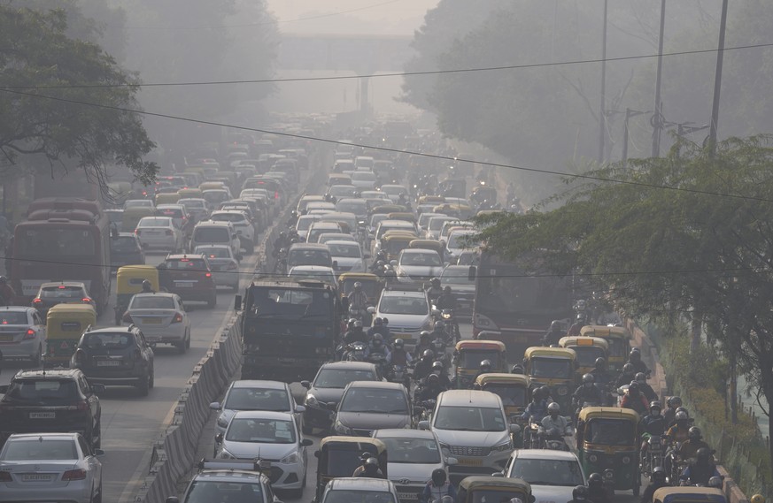 Commuters drive amidst morning haze and toxic smog in New Delhi, India, Wednesday, Nov. 17, 2021. Schools were closed indefinitely and some coal-based power plants shut down as the Indian capital and  ...
