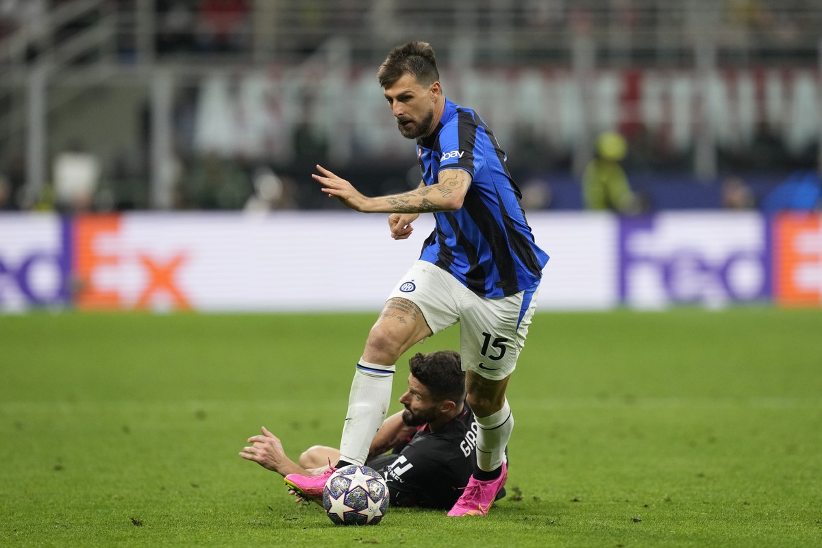 Inter Milan's Francesco Acerbi, top, runs with the ball past AC Milan's Olivier Giroud during the Champions League semifinal first leg soccer match between AC Milan and Inter Milan at the Sa ...