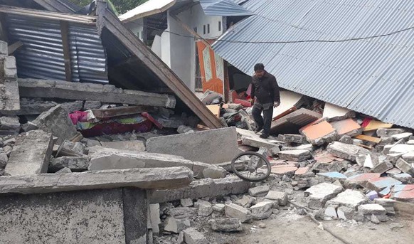 A man walks debris from destroyed houses in an area affected by an earthquake at Sajang village, Sembalun, East Lombok, Indonesia, Monday, July 30, 2018. A strong and shallow earthquake early Sunday k ...