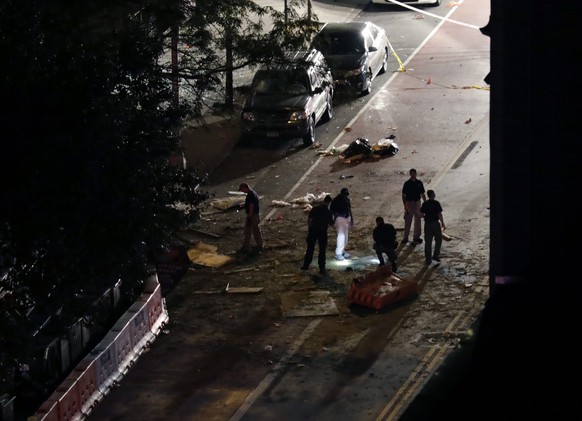 epa05545384 Police investigators look through the debris on the street in front of St. Vincent de Paul church where an explosion occurred on 23rd street between 6th and 7th Avenue in the borough of Ma ...