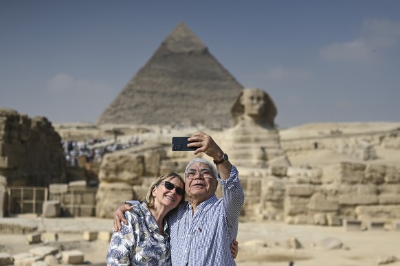 epa12493042 Two tourists take a selfie in front of the Sphinx at the Giza Plateau, home to the Great Pyramids of Giza, in Giza, Egypt, 30 October 2025, two days before the opening ceremony of the Gran ...