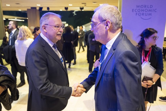 epa12663316 Managing Director of the World Economic Forum (WEF) Alois Zwinggi (L) shakes hands with Switzerland's Federal President Guy Parmelin (R) prior to a plenary session in the Congress Hal ...