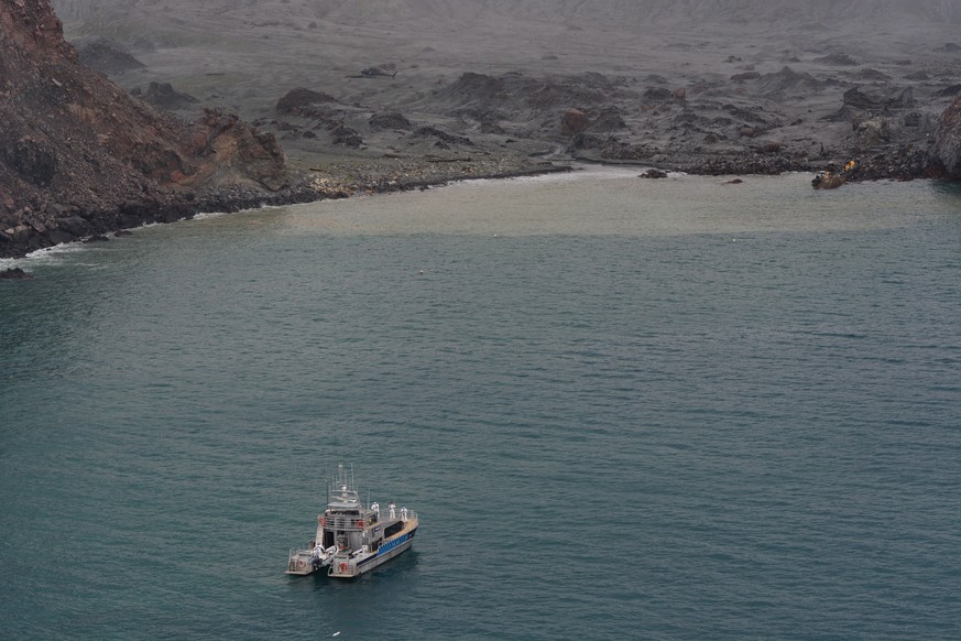 epa08068369 A handout photo made available by Royal New Zealand Navy shows police and Navy personnel during a recovery operation for the victims of a volcanic eruption on White Island, New Zealand, 13 ...