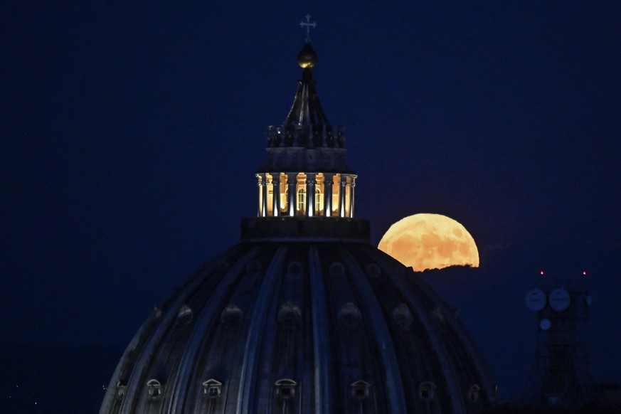 epa10069636 The Super Moon called the &#039;Buck Moon&#039; rises in the sky behind the the dome of St. Peter&#039;s Basilica in Vatican City seen from Rome, Italy, 13 July 2022. The Super moon is exp ...