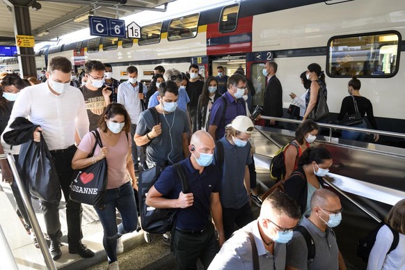 People wearing protective mask get out a SBB CFF train during the coronavirus disease (COVID-19) outbreak, at the train station CFF in Lausanne, Switzerland, Monday, July 6, 2020. In Switzerland, from ...