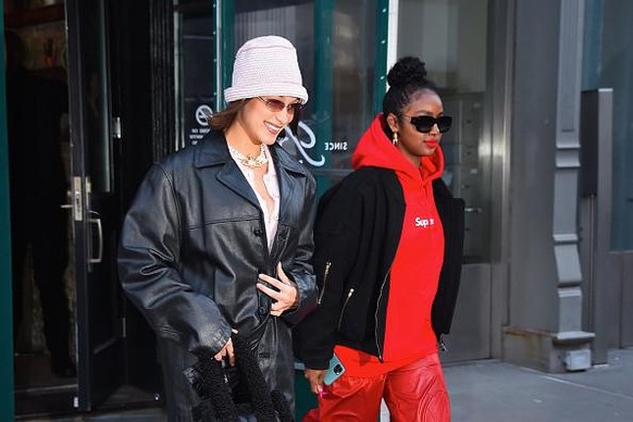 Model Bella Hadid und US-Sängerin Justine Skye in einem roten Supreme-Pulli.