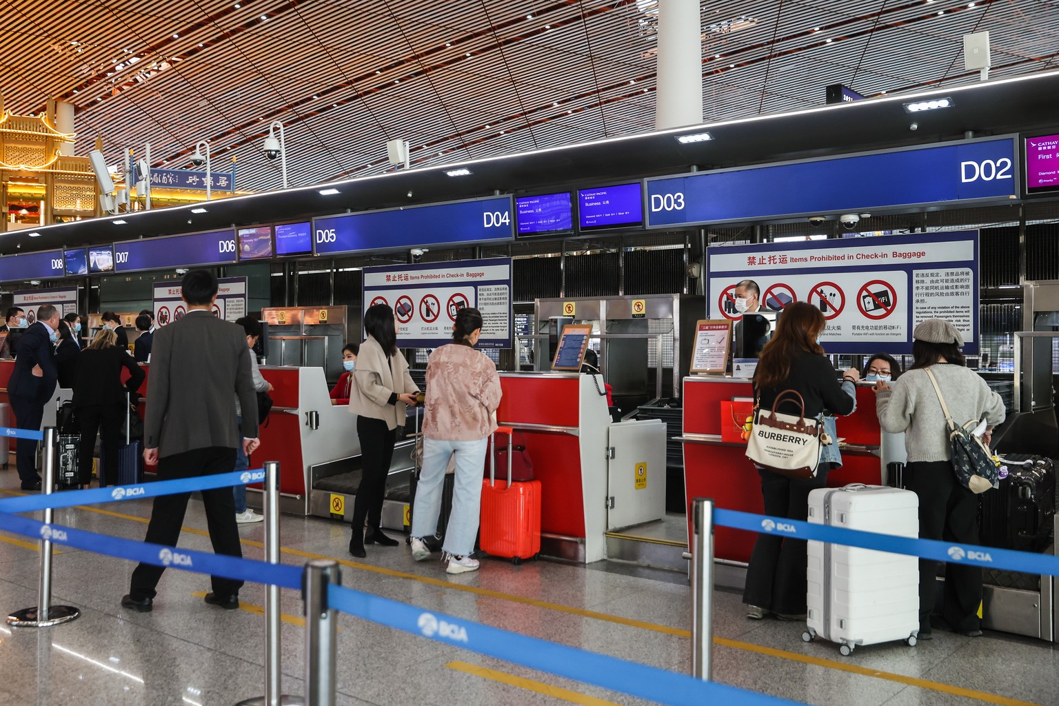 epa11217935 Chinese passengers wait in line at a check-in counter of Cathay Pacific Airways inside the Beijing Capital International Airport in Beijing, China, 13 March 2024. Hong Kong&#039;s Cathay P ...