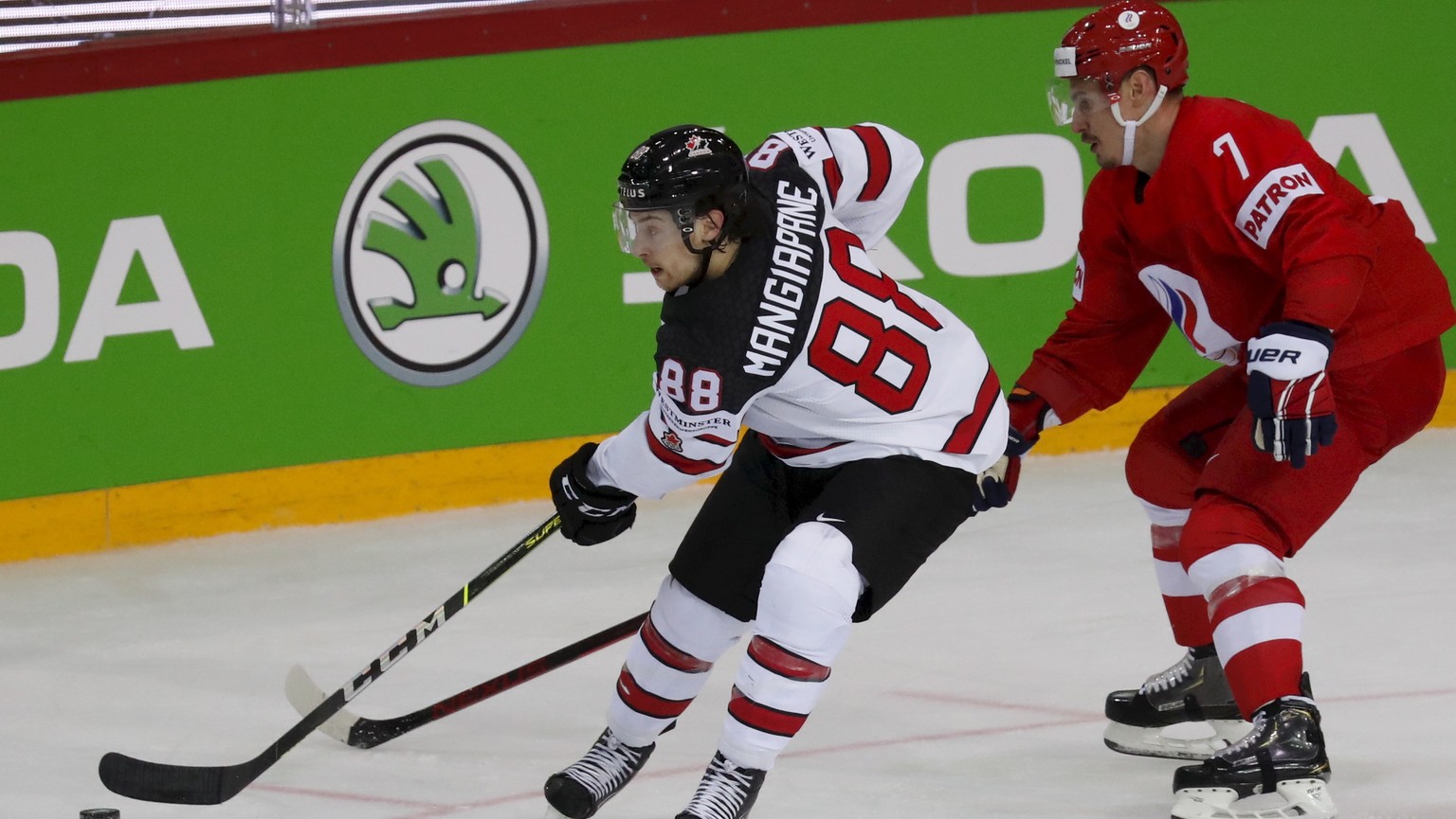 epa09245974 Dmitri Orlov (R) of Russia in action against Andrew Mangiapane (L) of Canada during the IIHF Ice Hockey World Championship 2021 quarter final match between Russia and Canada at the Olympic ...