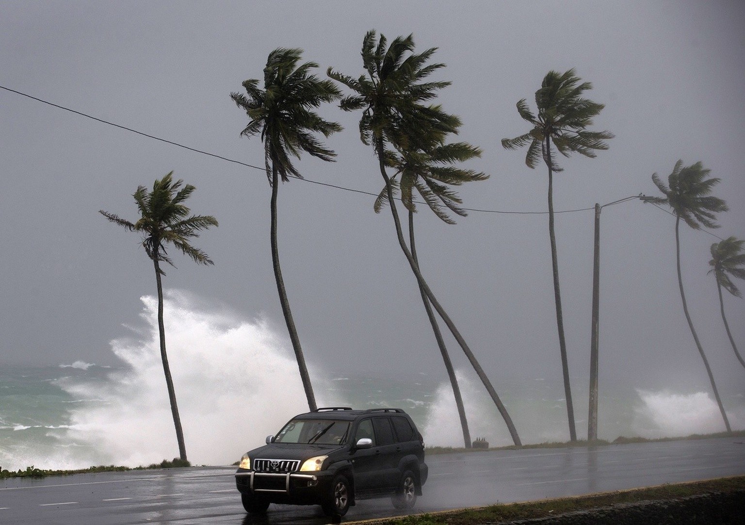 epa06218575 A vehicle drives along a beach after the passing of Hurricane Maria in Santo Domingo, Dominican Republic, 21 September 2017. Dominican emergency authorities warned that &#039;the worst has ...
