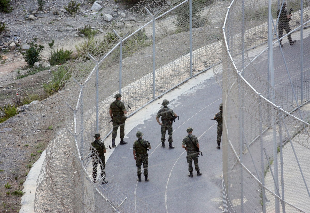 Spanish soldiers patrol the border which separates Spain's North African enclave of Ceuta from Morocco in Ceuta, Spain, Friday, Sept. 30, 2005. Soldiers with automatic weapons and police with ant ...