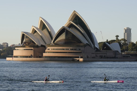 Kayakers paddle past the Sydney Opera House on Sydney Harbour, Friday, Sept. 17, 2021. (AP Photo/Mark Baker)