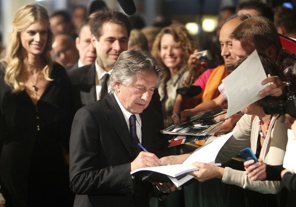 Polish born film director Roman Polanski writes autographs as he arrives to pick up the award for his life work at the Film Festival in Zurich, Swzitzerland, Tuesday, Sept.27, 2011. The award was inte ...