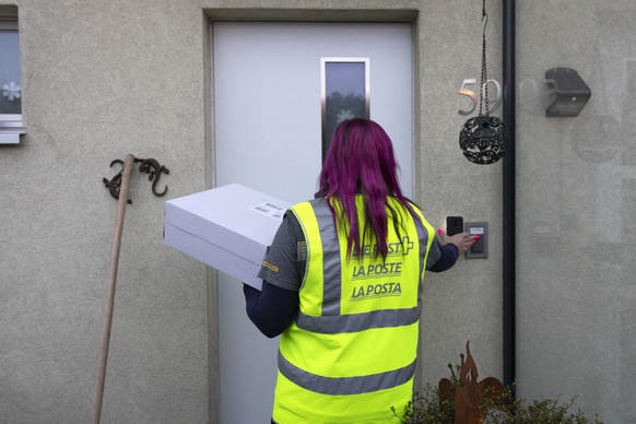 Leila Meyer, Paketbotin der Post, liefert Pakete aus, am Mittwoch, 9. Dezember 2020, in Egerkingen. (KEYSTONE/Peter Klaunzer)