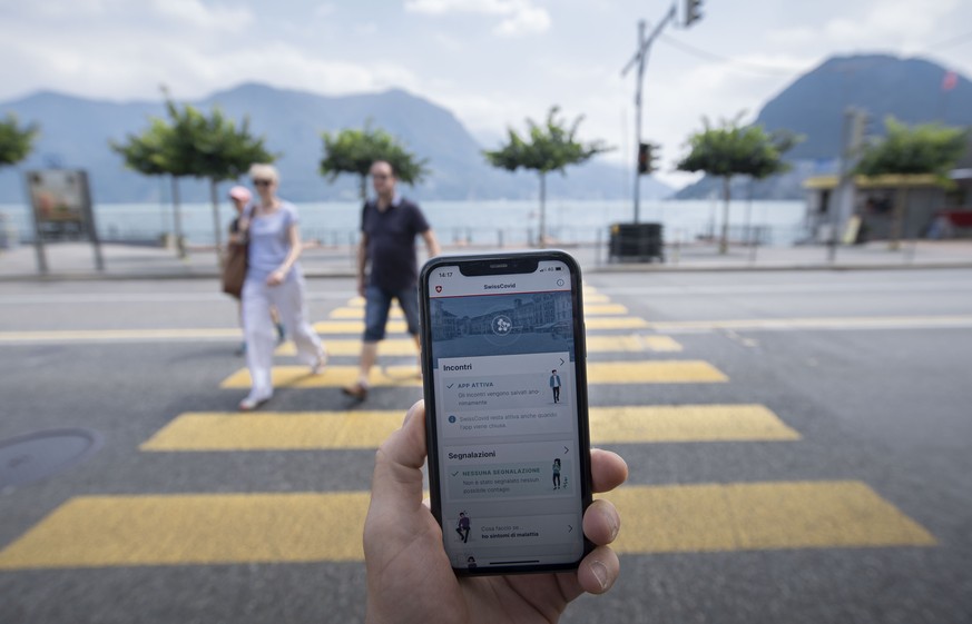 Eine Person nutzt die SwissCovid Contact Tracing App auf ihrem Smartphone, fotografiert am Donnerstag, 25. Juni 2020, in Lugano. (KEYSTONE/Ti-Press/Pablo Gianinazzi)